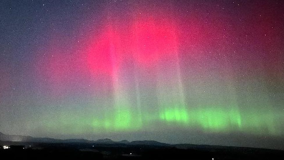 Red and green colours in the night sky