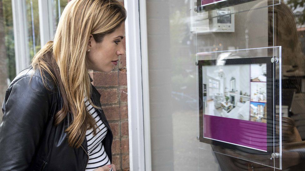 Woman looking at estate agents window