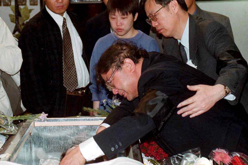 The father of Zhu Ying weeps over her coffin in Belgrade