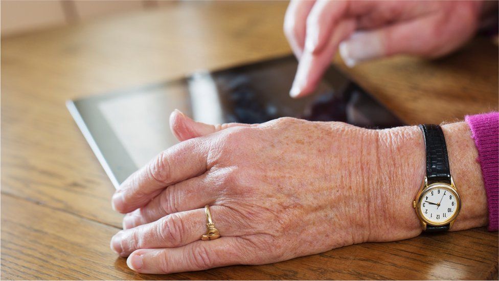 Pensioner enters details on tablet