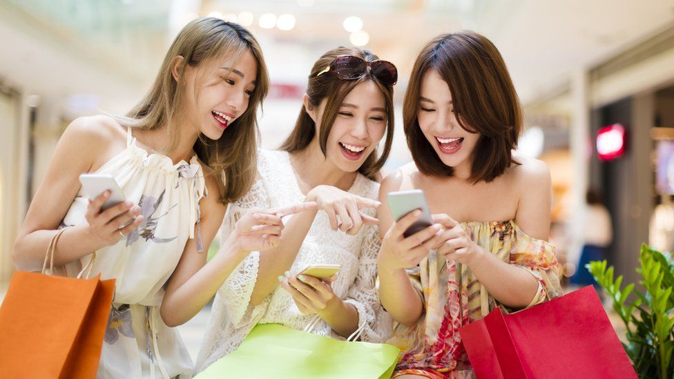 Young women launghing at smartphones