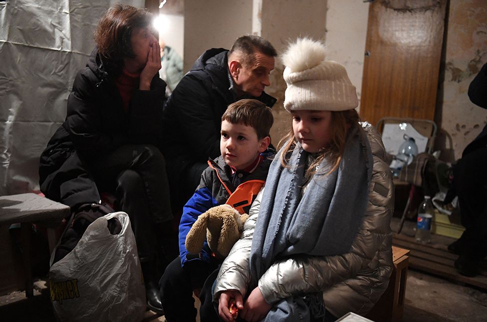 Kira Shapovalova and her brother Mikhailo wait in an underground shelter during bombing alert in the Ukrainian capital of Kyiv on February 26, 2022