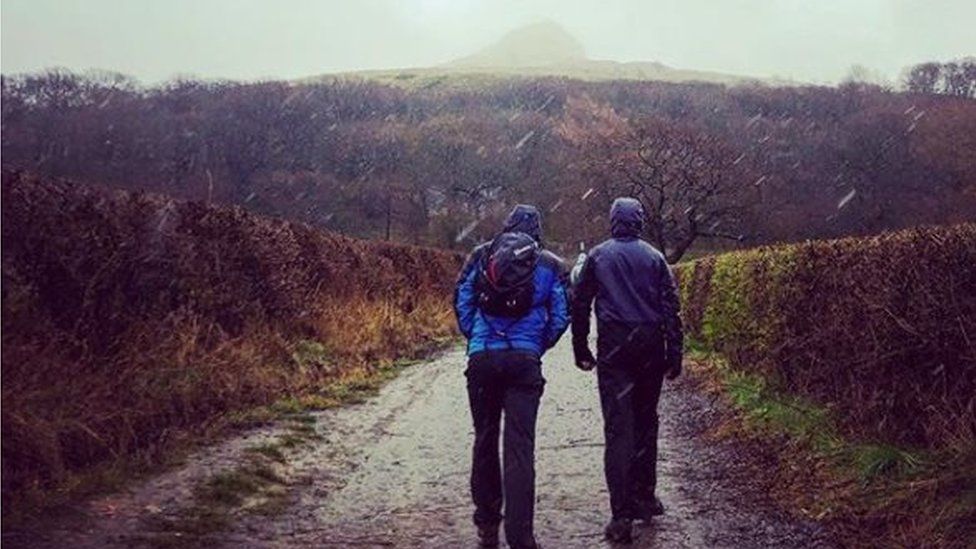 Walkers start to climb Roseberry Topping in the snow