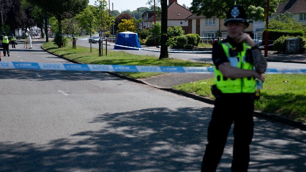 A police officer stands near the scene on College Road, Kingstanding, north of Birmingham