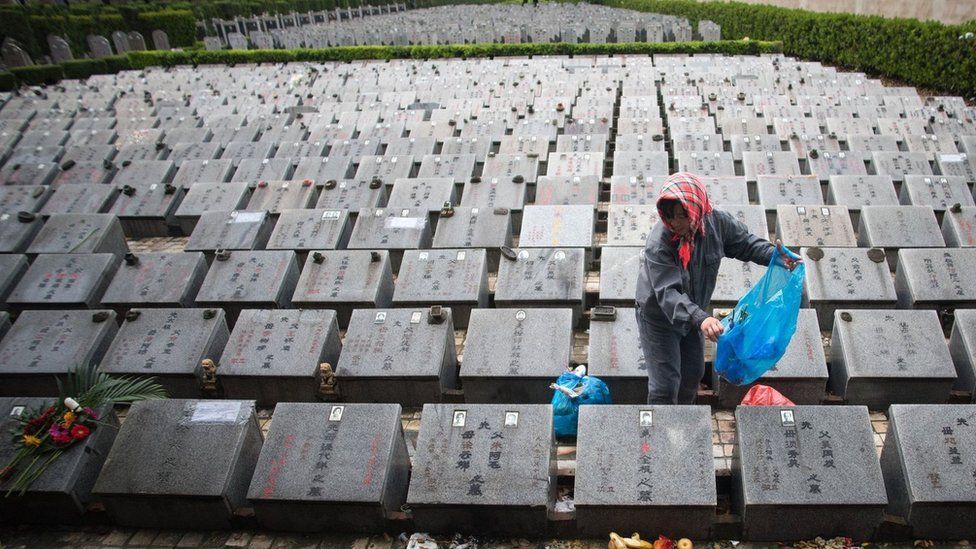 A worker cleans graves during the annual Qingming festival, or Tomb Sweeping Day, at a public cemetery in Shanghai on 6 April 2015.