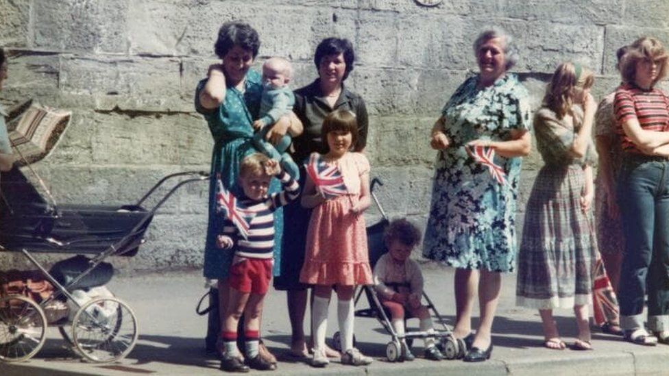 Alina's father Richard as a child. He is holding a union jack flag at a parade where he saw the Queen.