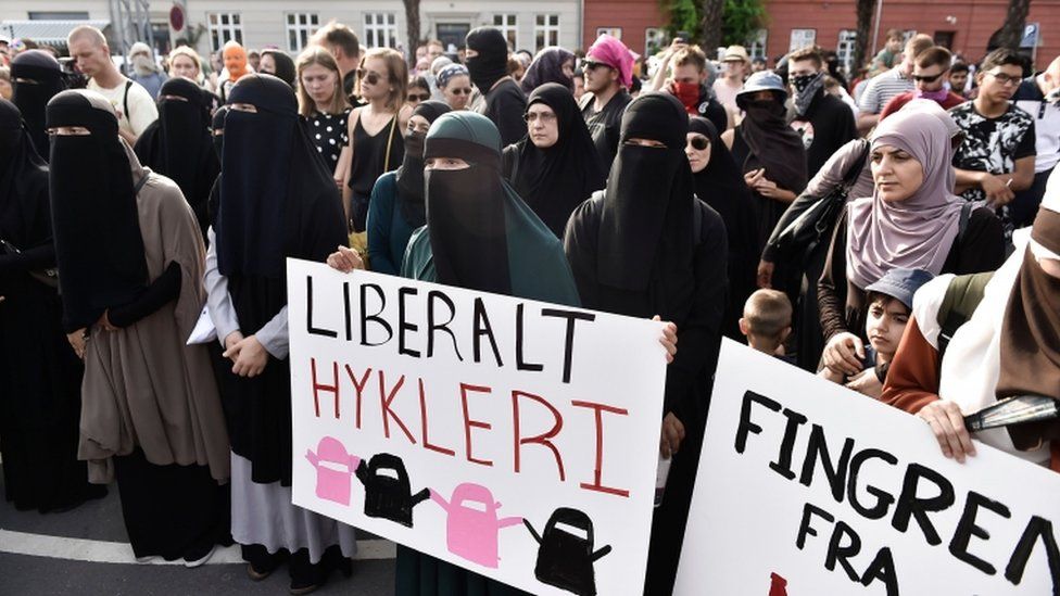 Women in veils protesting with signs