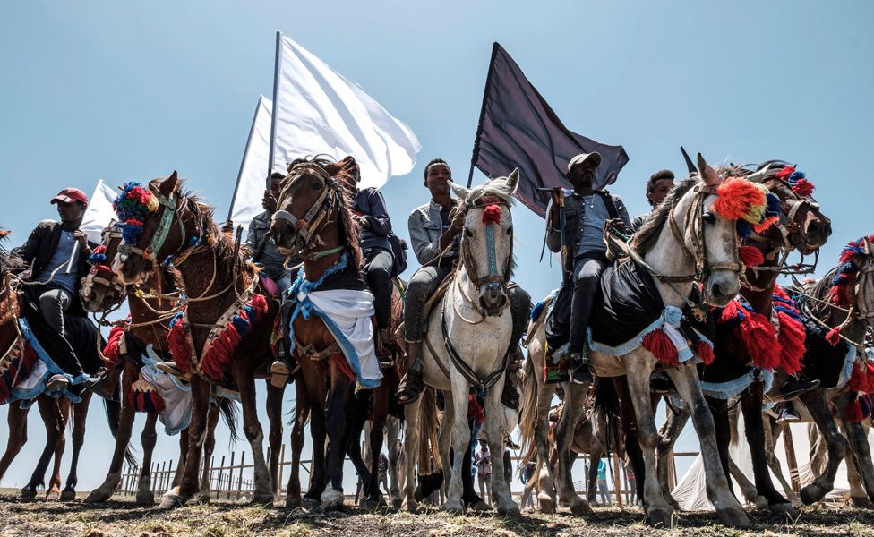 Horsemen hold black and white flags during a memorial ceremony at the crash site of the Ethiopian Airlines Flight 302 in Tulu Fara, Ethiopia - Sunday 8 March 2020