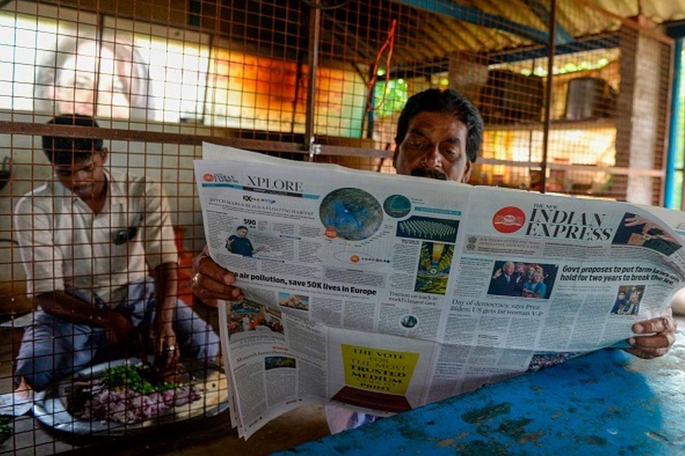 A man reads a newspaper featuring front-page news on US President Joe Biden and Vice President Kamala Harris at her ancestral village of Thulasendrapuram in the southern Indian state of Tamil Nadu on January 21, 2021