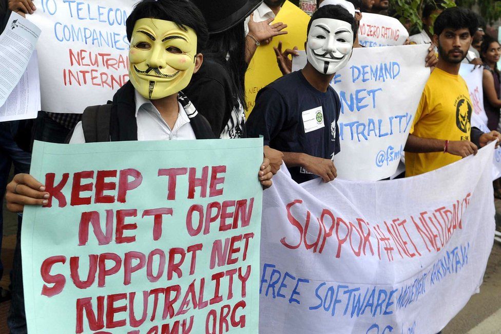 Indian activists wear masks as they hold placards during a demonstration supporting 'net neutrality' in Bangalore
