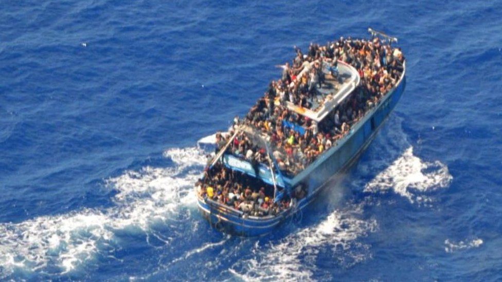 На недатированной фотографии, предоставленной греческой береговой охраной, показаны мигранты на борту лодки во время спасательной операции, прежде чем лодка перевернулась в открытом море у побережья Греции, 14 июня 2023 г.