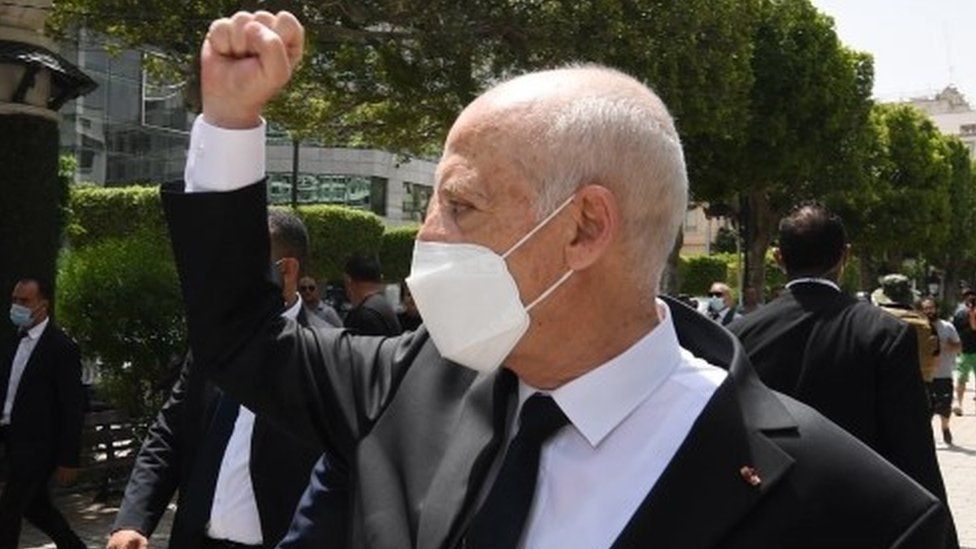 На раздаточной фотографии, предоставленной президентом Туниса, видно, как президент Туниса Кайс Сайед жестикулирует среди опор, пока он идет под охраной охраны на авеню Хабиба Бургиба, Тунис, Тунис, 1 августа 2021 г.