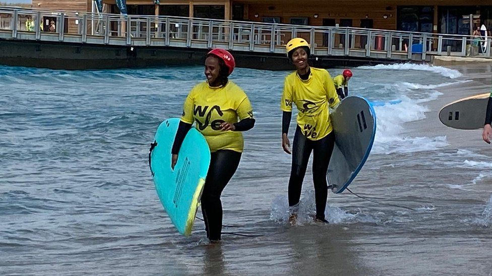 A group of muslim women/women of colour learning to surf