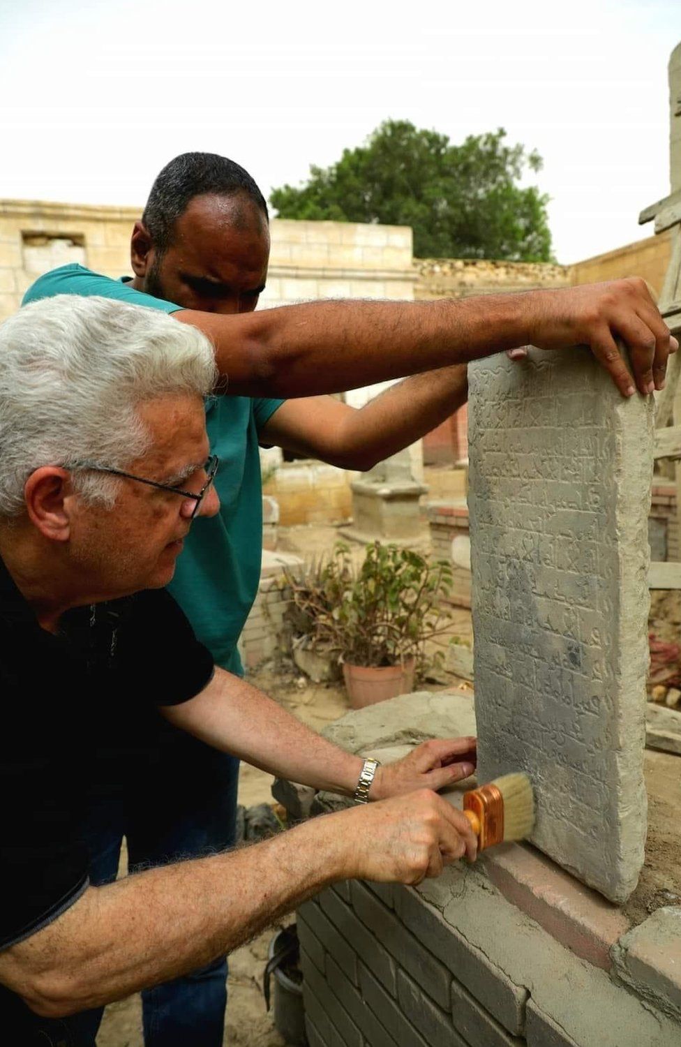 Dr Mostafa El-Sadek removing dust from a 9th Century tombstone he found by coincidence inside Imam Shafei cemetery