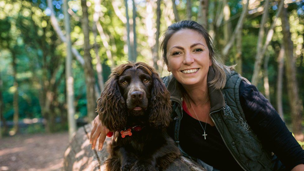 Hannah Molloy in a forest with her spaniel