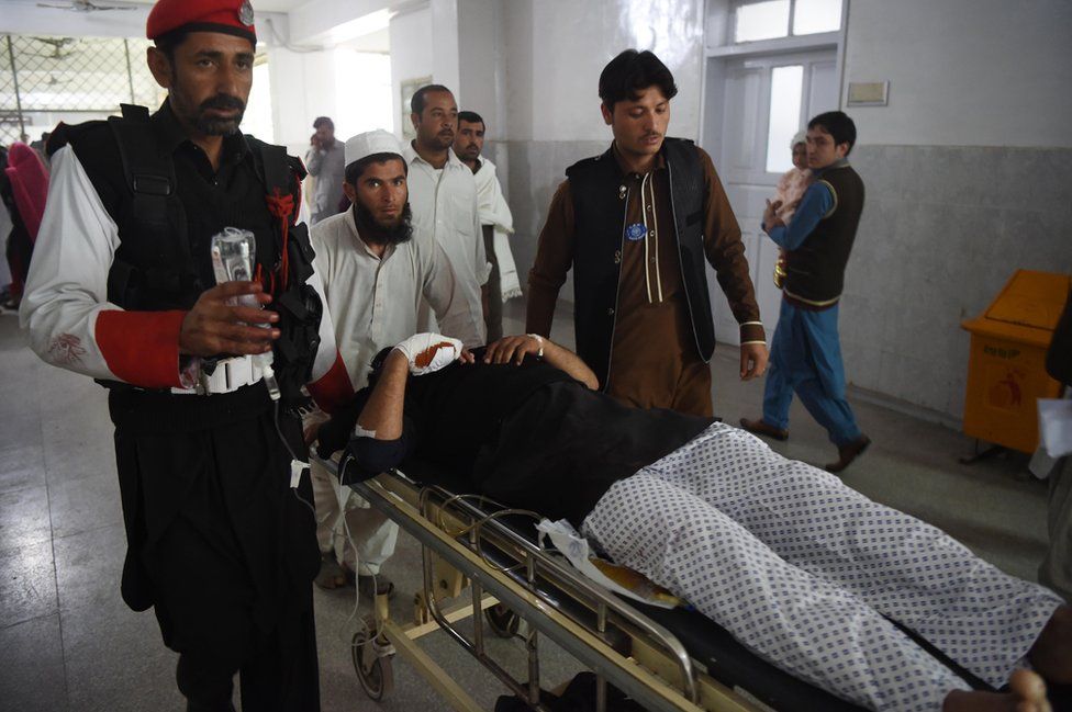 Pakistani medics move an injured security personnel for a treatment at a hospital in Peshawar on February 15, 2017