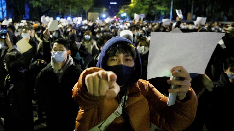 People hold white sheets of paper in protest over coronavirus disease (COVID-19) restrictions, after a vigil for the victims of a fire in Urumqi, as outbreaks of COVID-19 continue, in Beijing, China, November 27, 2022.