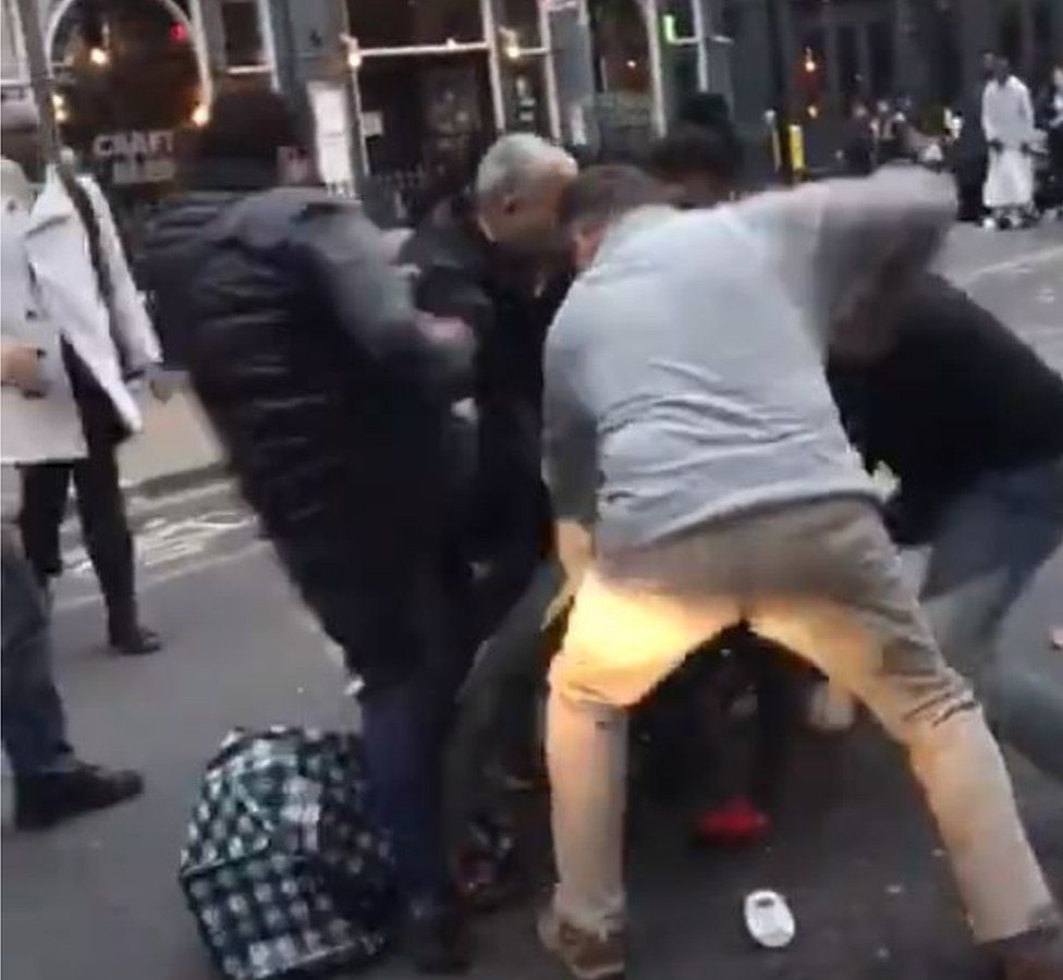Men pinning person to ground