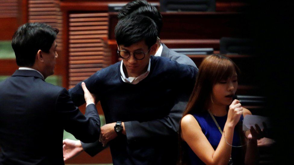Security guards block pro-independence legislator-elects Baggio Leung and Yau Wai-ching (R) from retaking their oaths inside the Legislative Council in Hong Kong, China November 2, 2016.