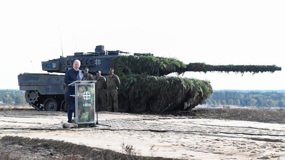 German Chancellor Olaf Scholz delivers a speech in front of a Leopard 2 tank in October 2022