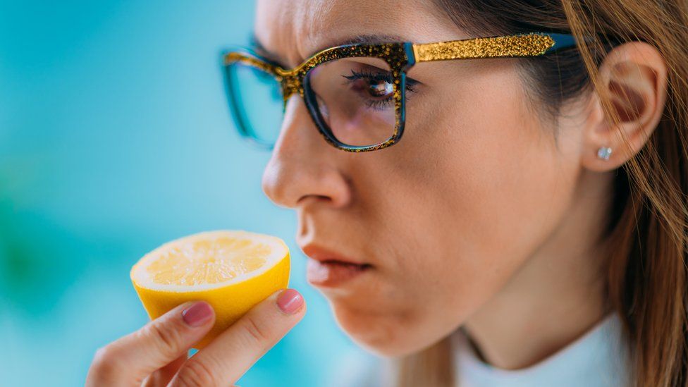 woman smelling a cut lemon