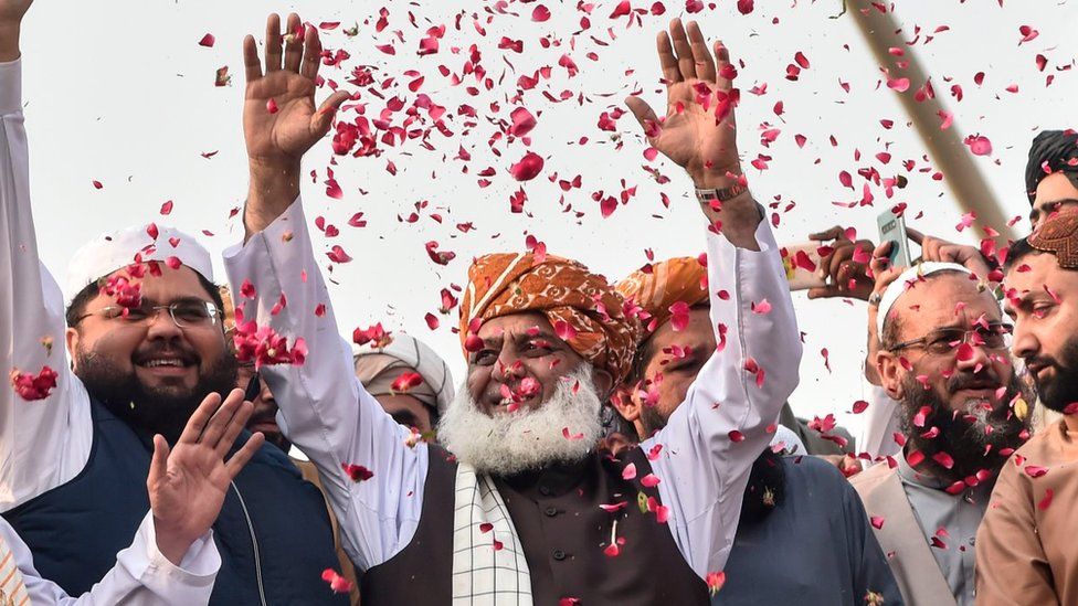 Chief of the Jamiat Ulema-e-Islam party Maulana Fazlur Rehman (C) gestures to supporters on his arrival during an anti-government "Azadi March" towards Islamabad, in Lahore on October 30, 2019.
