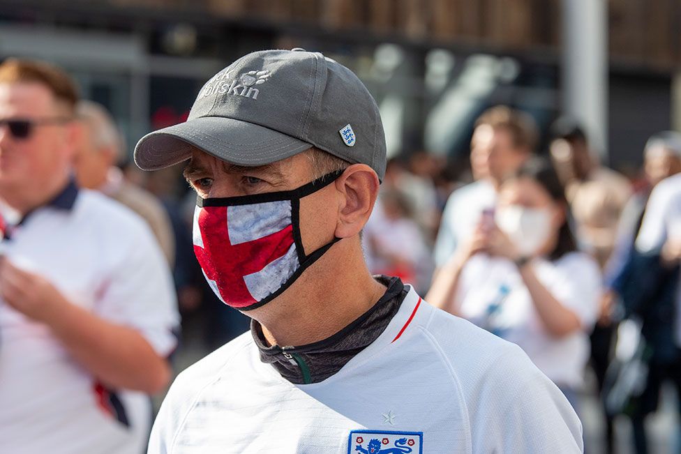 An England fan wears a St George cross face mask outside Wembley Stadium ahead of the England v Denmark UEFA Euro 2020 semi-final