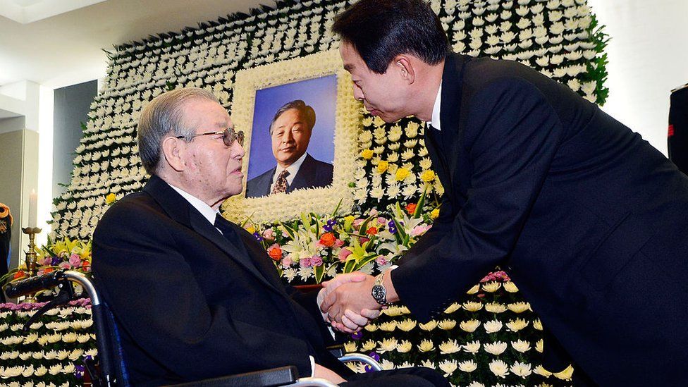 Kim Jong-Pil (L) consoles Kim Hyun-Chul (R), son of the late former South Korean president Kim Young-Sam, at a memorial altar