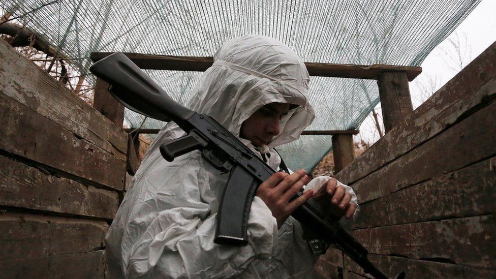 A militant of the self-proclaimed Donetsk People"s Republic (DNR) holds a weapon at fighting positions on the line of separation from the Ukrainian armed forces near the rebel-controlled settlement of Yasne (Yasnoye) in Donetsk region, Ukraine January 14, 2022.