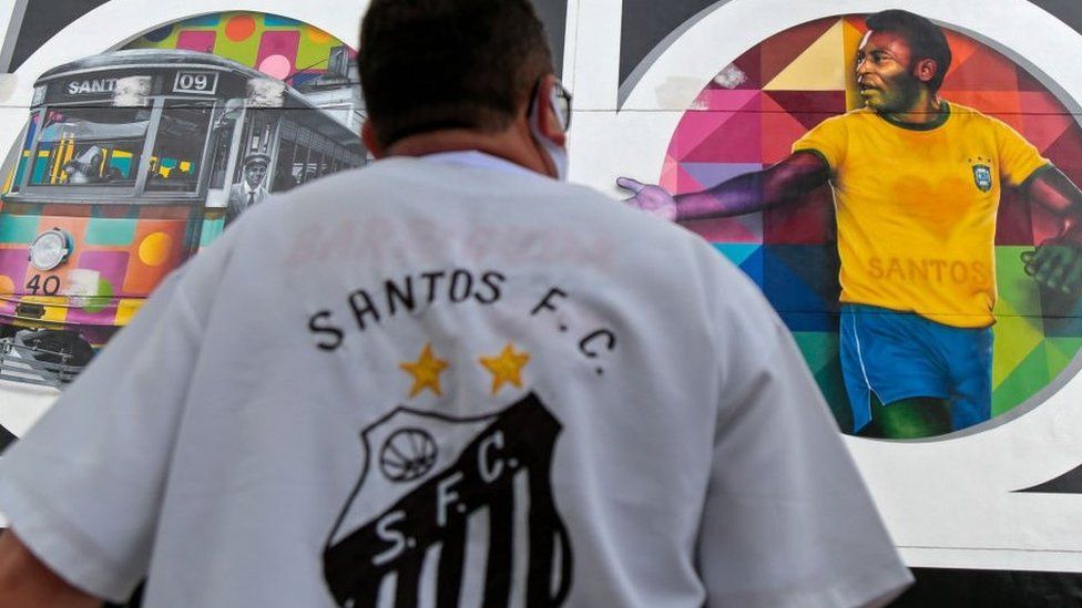 A fan of Santos football club looks at a mural by Brazilian artist Kobra