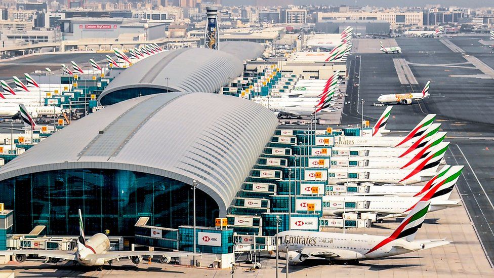 Много самолетов Эмирейтс припарковано у терминала аэропорта Дубая