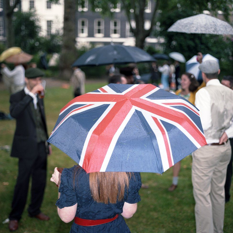 A woman holding a Union Jack umbrella