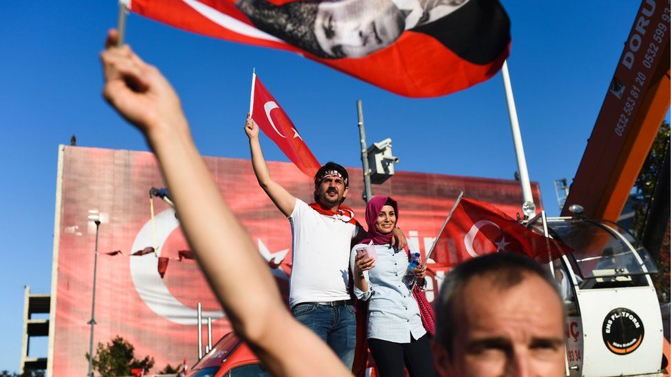Demonstrators wave Turkish flags and picture of Ataturk, founder of modern Turkey, in Istanbul's Taksim Square on 24 July 2016 during the first cross-party rally to condemn the coup attempt against President Recep Tayyip Erdogan.