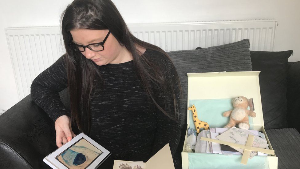 Kayleigh Atkins looking at a photo of her stillborn son