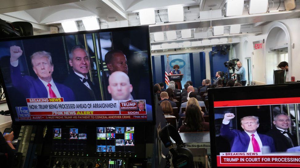 Трамп на экране телевизора во время пресс-брифинга в Белом доме