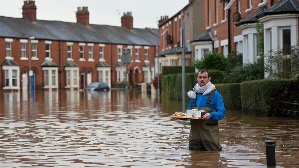 A man in a flooded street in Carlisle
