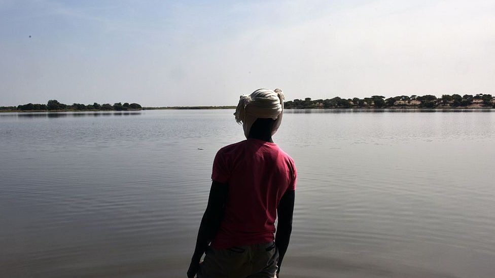 A survivor of a Boko Haram attack in Chad looking out over Lake Chad - archive