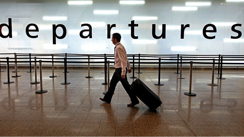 Man walking through departure lounge at airport