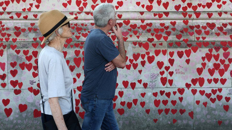 People walking past the Covid Memorial Wall in London