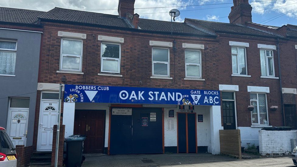 The Oak Stand entrance to Luton Town's front ground which is sandwiched between two terraced houses