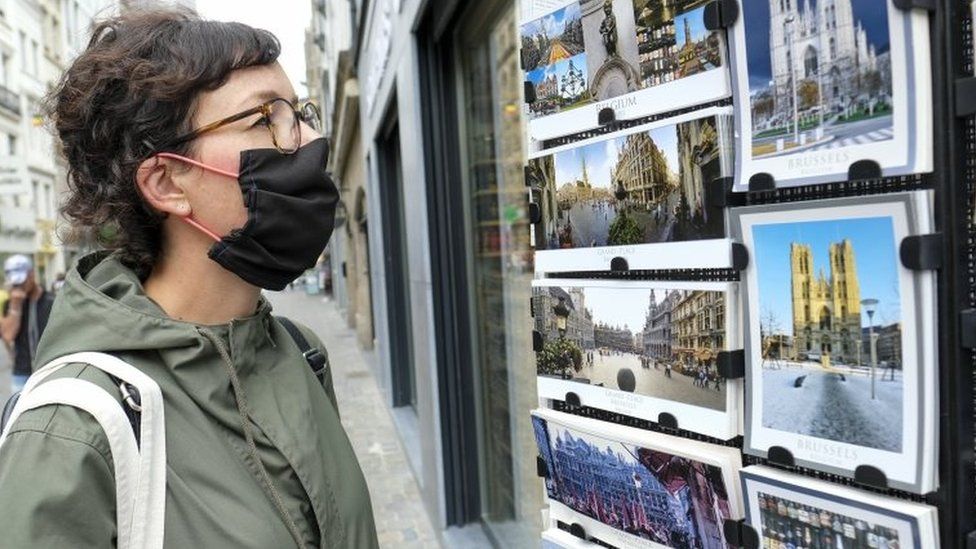 A woman looks at postcards of Brussels in Brussels, Belgium