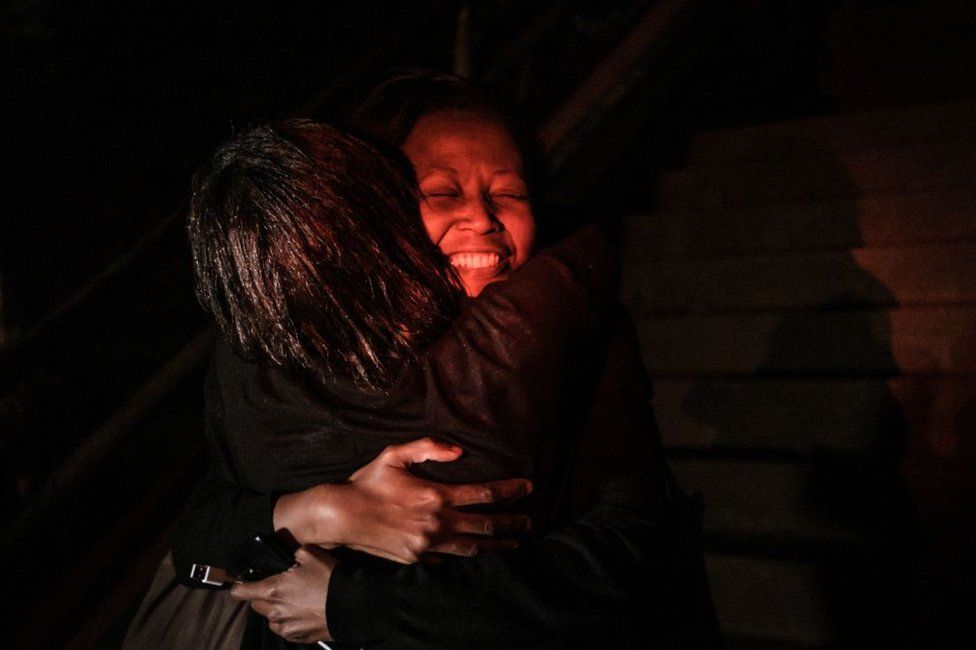 A woman reacts as she is reunited with family after being evacuated from the DusitD2 compound in Nairobi after a blast followed by a gun battle rocked the upmarket hotel complex on January 15, 2019.