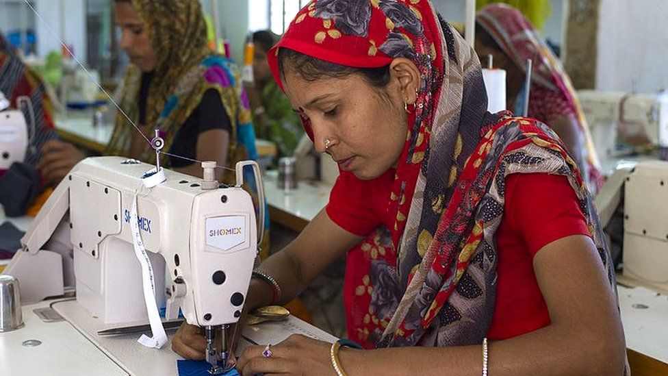 Indian woman sewing textiles at Dastkar women's craft co-operative, the Ranthambore Artisan Project, in Rajasthan, Northern India