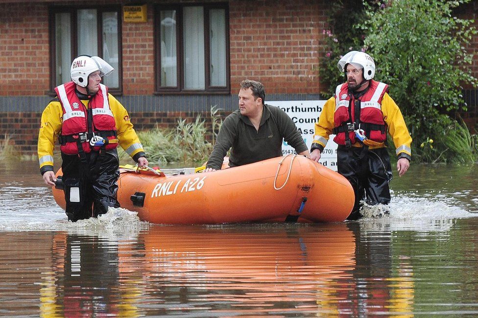 A resident is taken to safety aboard a dinghy