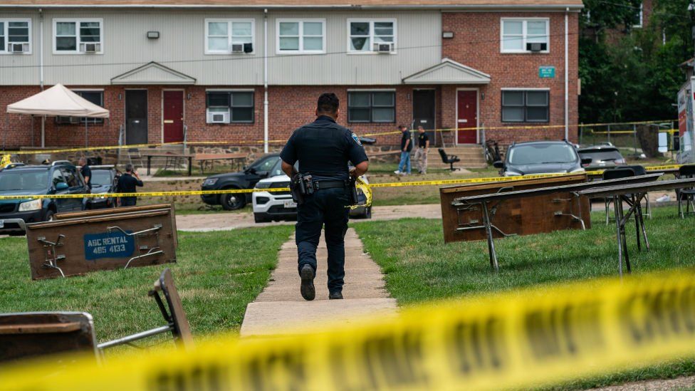 Baltimore Police investigate the site of a mass shooting in the Brooklyn Homes neighbourhood