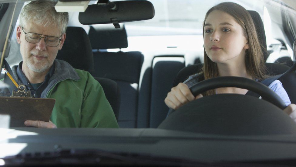 Male driving instructor with a young female student