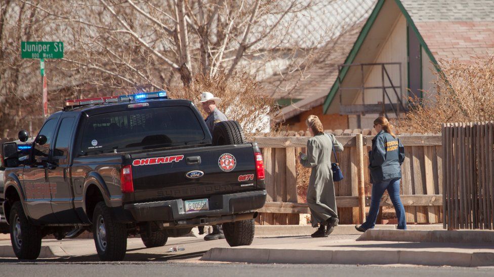 Law enforcement officers walk through Hildale, Utah on Tuesday, Feb. 23, 2016.