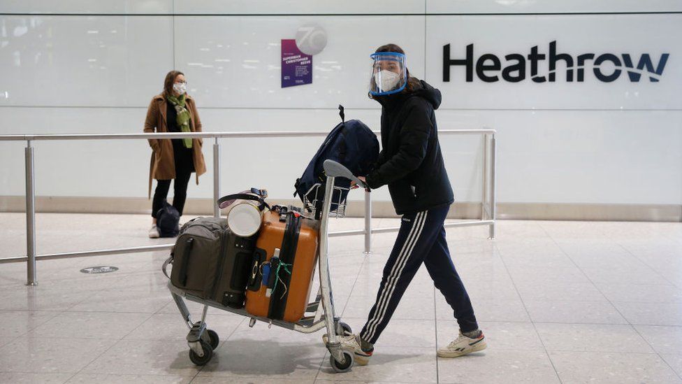 Passenger in face mask in airport arrivals hall