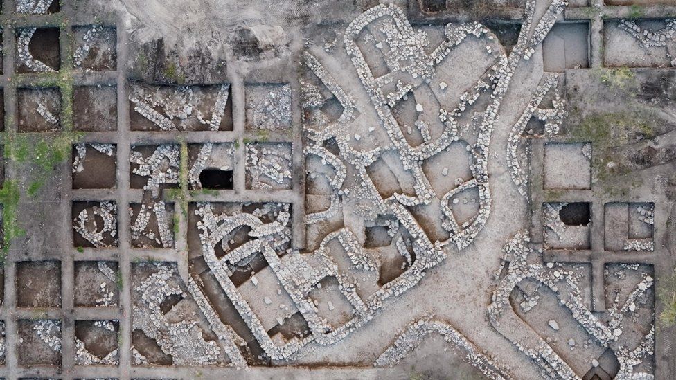 An overhead photo of the excavation site gives a clear view of the planned design of the ancient city.