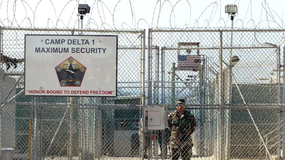 A U.S. Army soldier stands at the entrance to Camp Delta where detainees from the U.S. war in Afghanistan live April 7, 2004 in Guantanamo Bay, Cuba